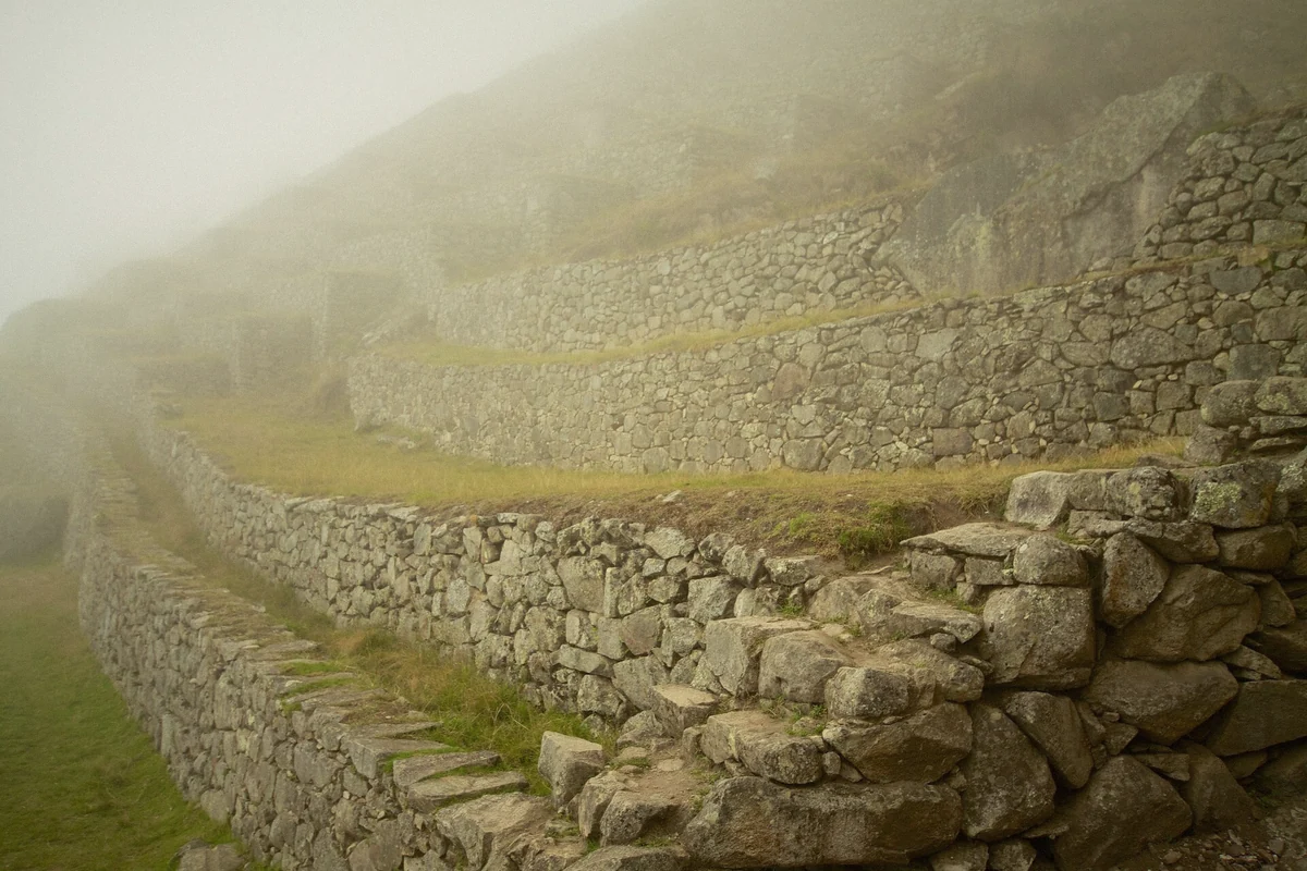 Morning mist lifting off the Machu Picchu terraces in cold early light, Peru